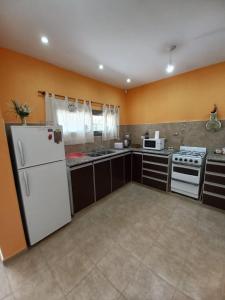 a kitchen with a white refrigerator and a stove at LA SERENA, Casa Serrana in Río Ceballos