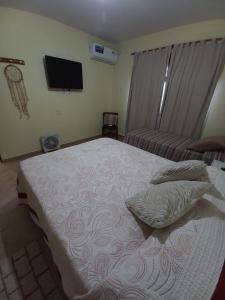 a bedroom with a bed with two pillows and a tv at LA SERENA, Casa Serrana in Río Ceballos +13 photos