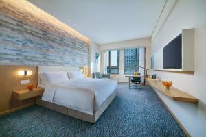 a hotel room with a large bed and a flat screen tv at Holiday Inn Express Nantong Textile City by IHG in Tongzhou +39 photos