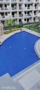 een groot blauw zwembad voor een gebouw bij Junior Suite 1 bedroom Resort type Condo Near Naia in Manilla