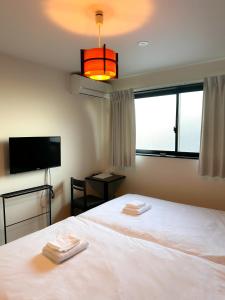um quarto com uma cama branca com duas toalhas em Ostay Kyoto west hotel APT em Quioto