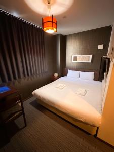 ein Hotelzimmer mit einem großen Bett und einer Lampe in der Unterkunft Ostay Kyoto west hotel APT in Kyoto