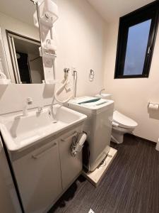 a bathroom with a sink and a toilet and a mirror at Ostay Kyoto west hotel APT in Kyoto