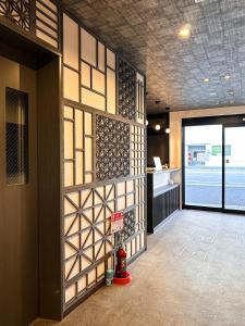 um quarto com uma parede com painéis de madeira e uma porta em Ostay Kyoto west hotel APT em Quioto
