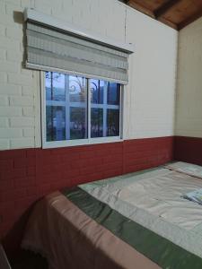 Cette chambre comprend un lit et une fenêtre. dans l'établissement Villa Lucy, à Charalá