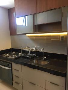 a kitchen with a sink and a stove at Flat novo e estiloso na praia Ponta de Campina in Cabedelo