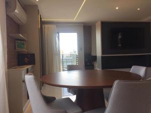 a room with a table and chairs and a window at Flat novo e estiloso na praia Ponta de Campina in Cabedelo