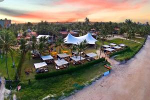 an aerial view of a resort with tents and palm trees at Flat novo e estiloso na praia Ponta de Campina in Cabedelo