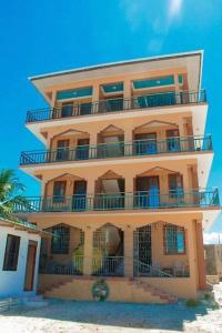 a tall building with balconies on the beach at Stardust Villa - ** Hotel in Paje