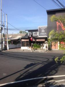 two people crossing a street in front of a building at simple apartment 2 in Seminyak