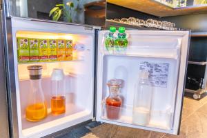 einen offenen Kühlschrank mit vielen Getränken und Flaschen in der Unterkunft glampark ACONCAGUA RESORTS in Minami Aso