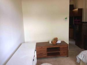 um quarto com uma cama e uma mesa de madeira em simple apartment 2 em Seminyak