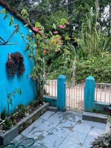 Una pared azul con una puerta con flores. en BLUE HOUSE CONEXÃO ILHA GRANDE en Ilha Grande