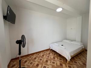 um quarto com uma cama, uma televisão e um tripé em MIHAHI BEACH em Máncora