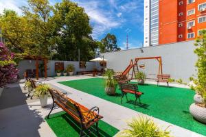 a courtyard with benches and a green lawn at Maravilhoso Próx. Atitus c/Garagem NOVO in Passo Fundo