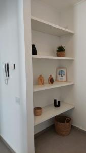 a room with white shelves with hats and baskets at Departamentos del Trébol in Necochea