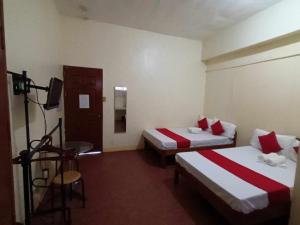 une chambre d'hôtel avec 2 lits et un appareil photo dans l'établissement William Hearts Pension, à Puerto Princesa 8 autres photos