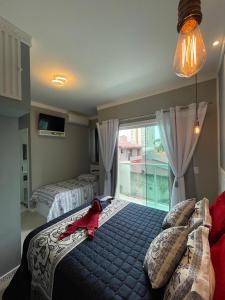 - une chambre avec un lit et une grande fenêtre dans l'établissement Apartamento Residencial Alves Balneário Piçarras, à Balneário Piçarras