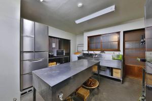a large kitchen with a large stainless steel counter top at 古民家さくらや in Atami