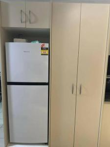 a white refrigerator in a kitchen next to cabinets at Ambitious Apartment Lot 7 in Nadi