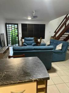 a living room with a blue couch and a table at Ambitious Apartment Lot 7 in Nadi