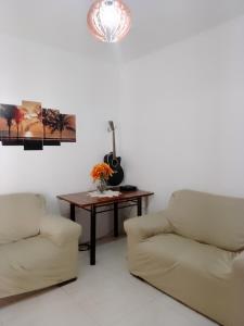 - un salon avec deux chaises et une table avec une guitare dans l'établissement Canto do sol, à Cabo Frio