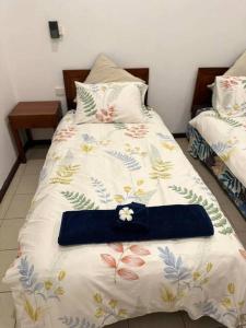 a bed with a blue bow tie on top of it at Ambitious Apartment Lot 7 in Nadi