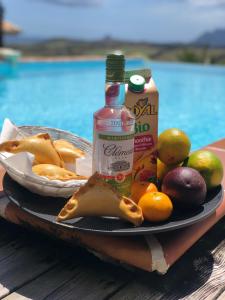 a plate of food with fruit and a bottle of alcohol at Sainte Luce_Villa_Piscine avec vue mer_wifi in Sainte-Luce