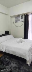 een slaapkamer met 2 bedden en airconditioning bij Elegant 1 bedroom Deluxe Suite Near NAIA in Manilla