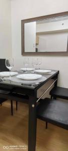 een tafel met wijnglazen en een spiegel bij Elegant 1 bedroom Deluxe Suite Near NAIA in Manilla