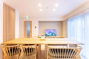 une salle à manger avec une grande table et des chaises en bois dans l'établissement Stagione Hakone Yumoto Villa スタジオーネ箱根湯本VILLA, à Hakone