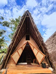 a thatch roofed house with a blue sky in the background at Wonderland in Siquijor