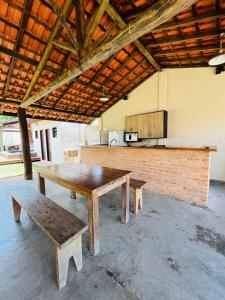 mesa de picnic y bancos en una habitación con cocina en Espaço Ranchão com Piscina em São Pedro - SP en São Pedro