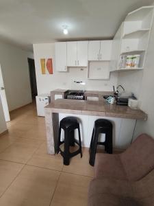 - une cuisine avec un comptoir et des tabourets dans une pièce dans l'établissement Bonito Depa, cómodo y bien ubicado, à Punta Hermosa