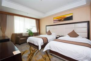 a hotel room with two beds and a chair at Vienna International Hotel - Shanghai World Expo Garden in Shanghai