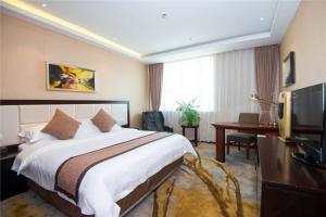 a hotel room with a bed and a desk and a television at Vienna International Hotel - Shanghai World Expo Garden in Shanghai