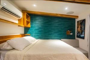 - une chambre avec un lit blanc et un mur bleu dans l'établissement Condo VNV walking to Playa Guiones, à Nosara