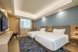 Cette chambre comprend deux lits et une télévision. dans l'établissement Holiday Inn Express Chengdu Tianfu Square, an IHG Hotel - Chunxi Road and Taikoo Li, à Chengdu