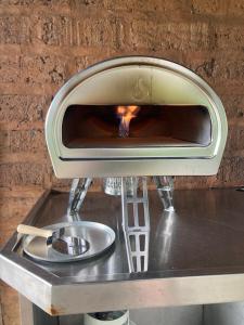 a pizza oven with a fire inside of it at A Stylish and Unique Retreat at Surf Beach in Surf Beach