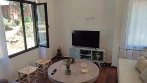 a living room with a table and a tv at Manantial MAR AZUL in Mar Azul