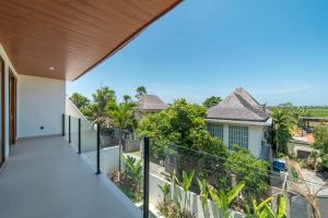 einen Balkon mit Blick auf ein Haus in der Unterkunft Villa Phan - Tranquil Stylish 2-Bedroom Villa in Pererenan in Munggu
