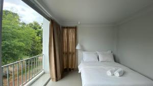 - une chambre avec un lit et une grande fenêtre dans l'établissement baan thammada, à Nan