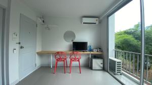 a room with a desk with a computer on a balcony at baan thammada in Nan