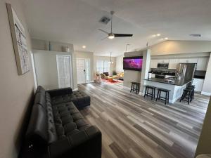 a large living room with a couch and a kitchen at Manatee Oasis Weeki Wachee Family Fun Pool Home in Spring Hill