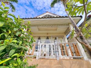 a house with a porch with a chair and trees at Prathana Garden Beach Resort in Hua Hin