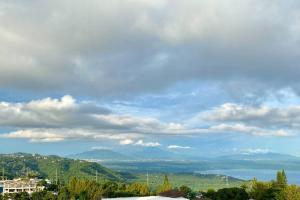 een uitzicht op de bergen en een blauwe lucht met wolken bij Weekend hideaway in Tagaytay