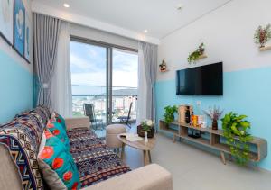 a living room with a couch and a tv at The Sóng Apartment - Nhà Của Kim in Vung Tau