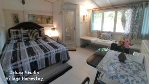 una camera da letto con un letto e un tavolo di Village Homestay a Udon Thani