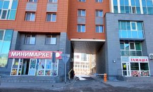 aartment building with a building with a sign on it at ЖК Времена года - Осень in Taldykolʼ