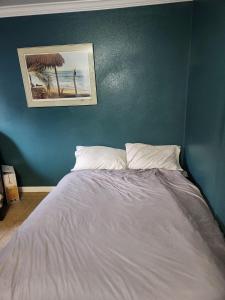 een bed in een kamer met een blauwe muur bij Huntington Beach in Huntington Beach